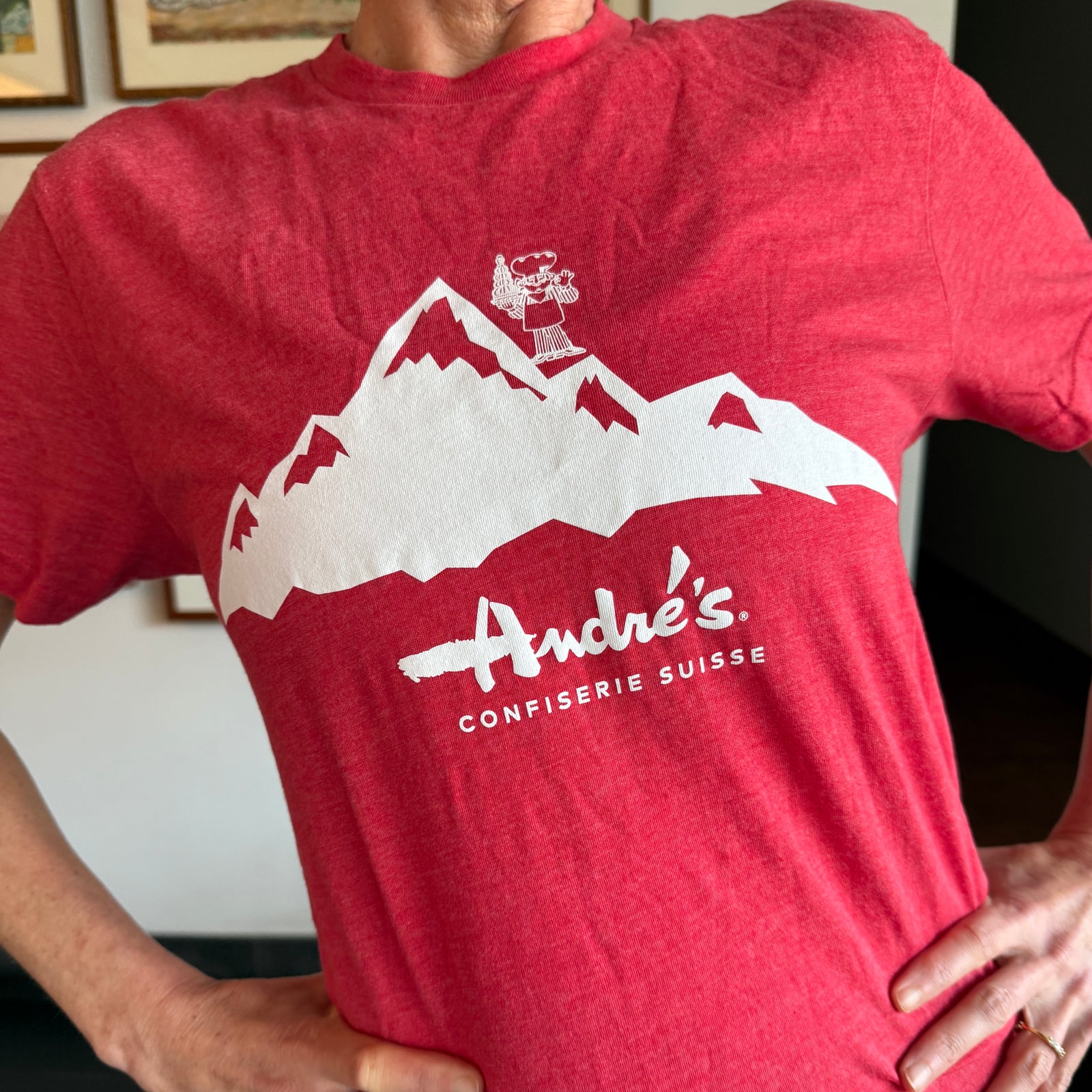 Red t-shirt with white mountain design and 'André's' branding worn by a person.