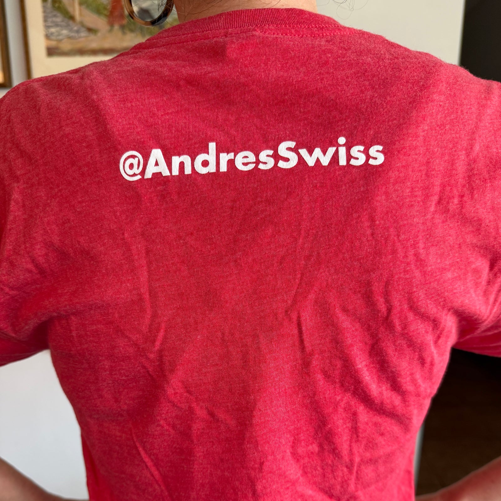 Red t-shirt with white mountain design and 'André's' branding worn by a person.