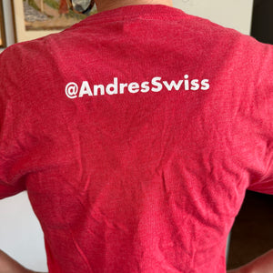Red t-shirt with '@AndresSwiss' text on the back, worn by a person.