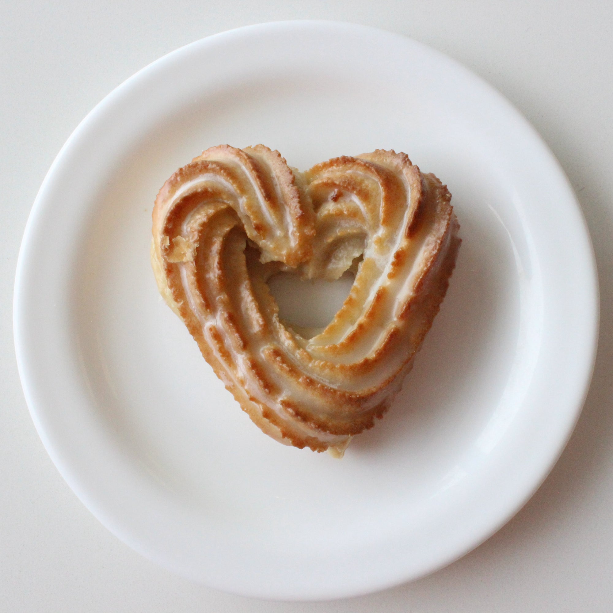 Heart-shaped almond cookie on a white plate