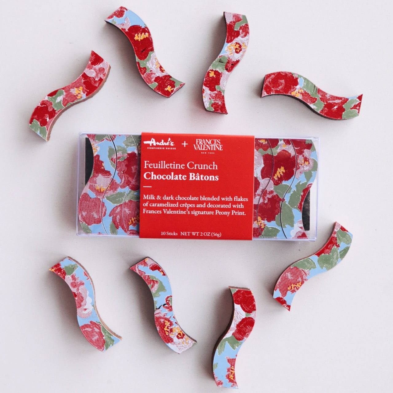 box of chocolate batons with Frances Valentine signature floral print, cut into curved sticks, with loose batons around