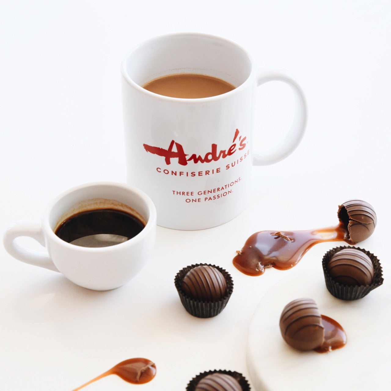collection photo of the individually packaged contents of the Hot Chocolate Bundle: Hot Chocolate jar, mug, hot chocolate bag, whiskey caramel drops box, mint leaves box. All with red & white Swiss print packaging.