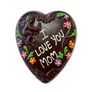 Dark chocolate heart with cupid and scoll design and "I Love You Mom" written in white chocolate and spring color flower detail.