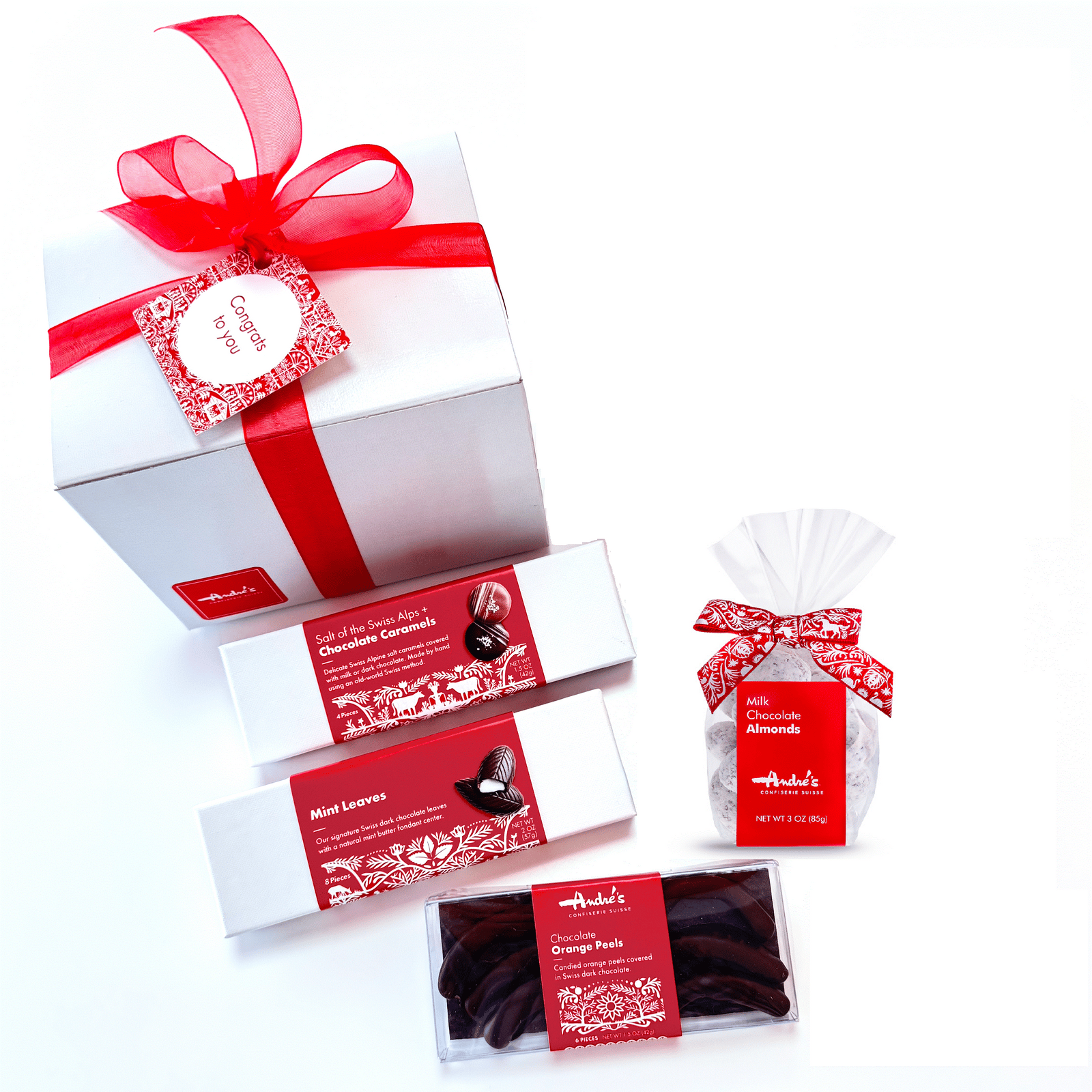 Collection of items for gift box next to a closed box with red ribbon and congrats hang tag.