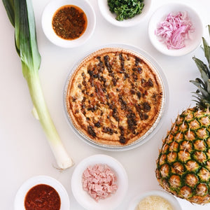 Quiche with various ingredients on a white surface