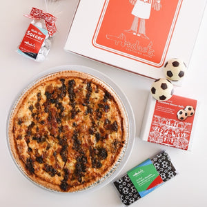 Quiche with soccer-themed packaging and items on a white surface