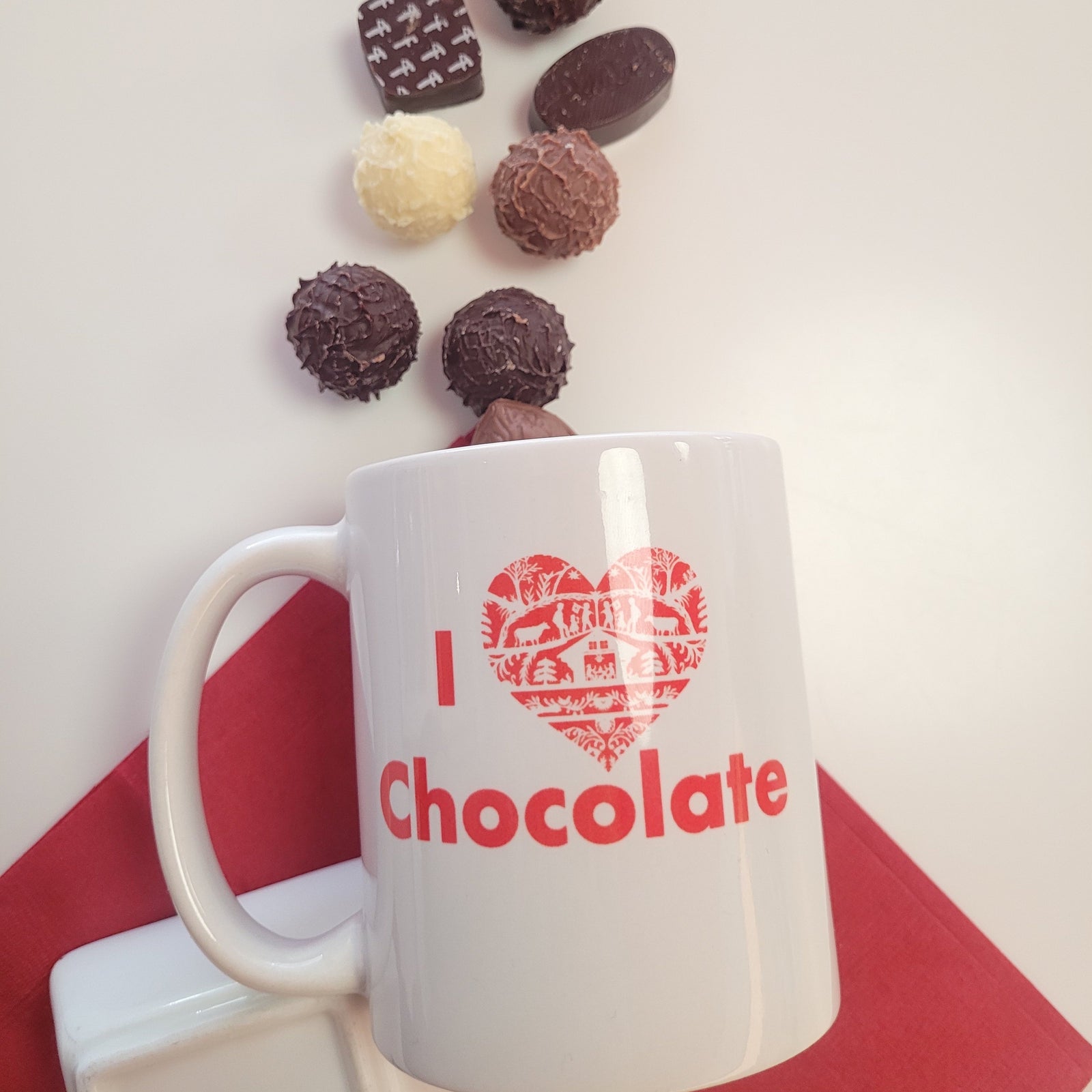 white coffee mug with "I (heart) Chocolate" in red with a quaint Swiss pattern in the heart.