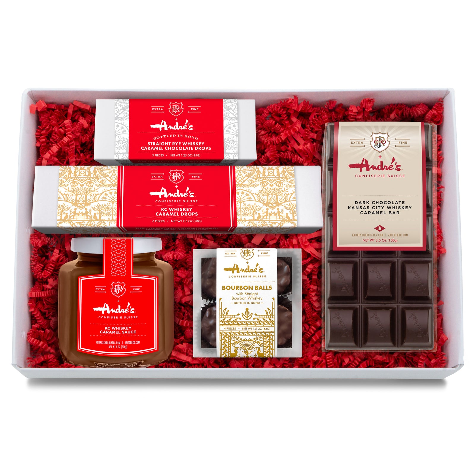 Overhead view of the items in the Whiskey Chocolate Gift Set arranged on a table. All of them have signature Andre's and J Rieger Co packaging.