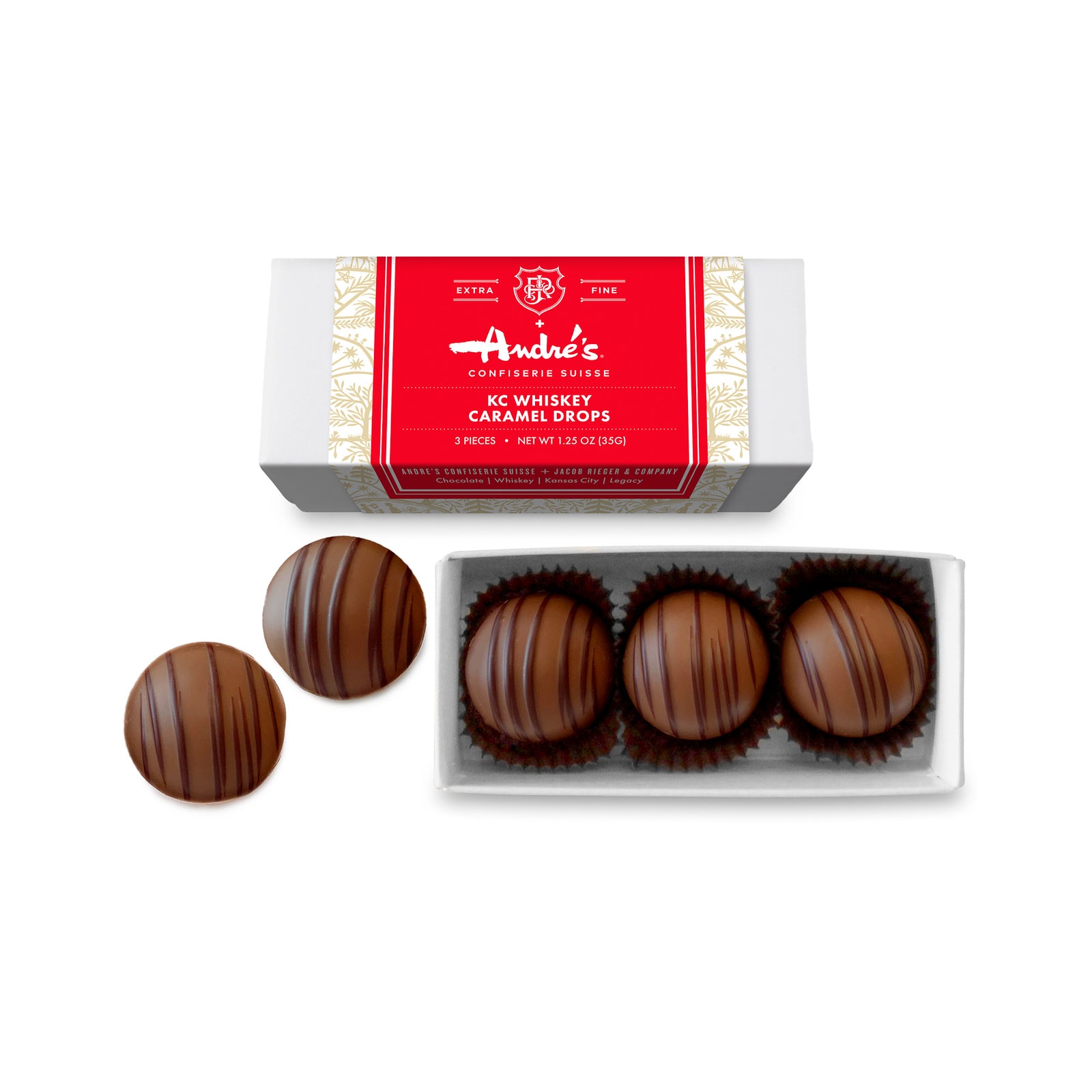Long box with 6 round milk chocolate candies inside, 2 loose candies, and 2 closed boxes with red, white and gold product information labels
