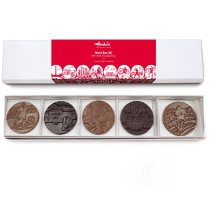 Set of five round chocolate candies in a box with a red label on a white background