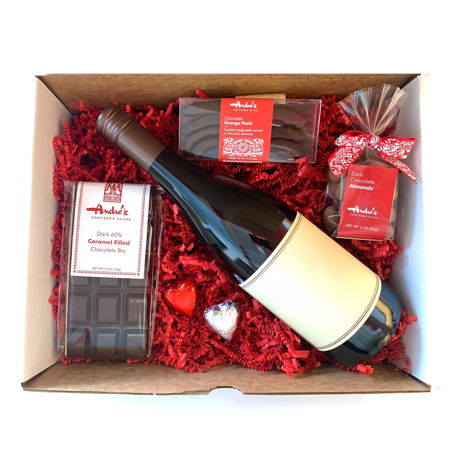 Overhead view of box with red wine bottle and chocolate treats all packed with red springfill