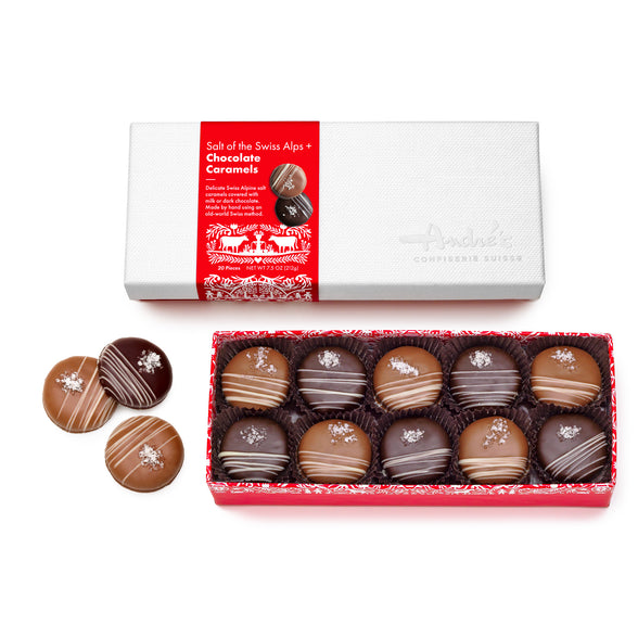 open red box base with top row of 10 caramels visible, alternating milk and dark covered, each with small white chocolate stripe accent and cluster of salt crystals. 3 loose candies beside and closed white lid box above with red and white Swiss print packaging.