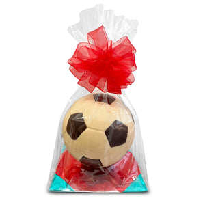 Soccer ball-shaped chocolate in a clear bag with a red bow on a white background