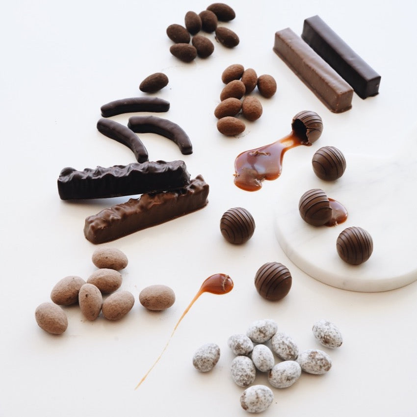 Assorted chocolate treats: almonds, marzipan, caramels, and orange peel.