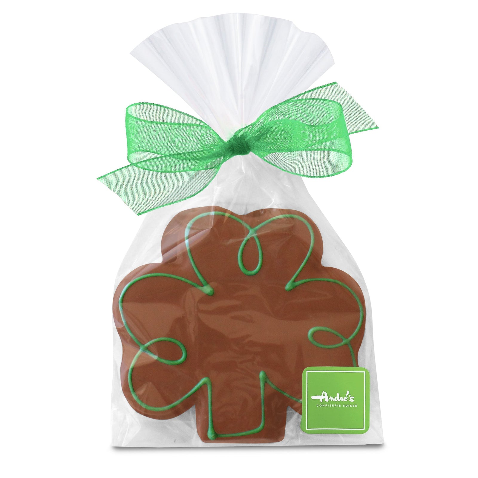 A clover leaf-shaped cookie, covered in milk chocolate and decorated with green swirls, in a clear bag with a green bow and Andre's logo sticker.