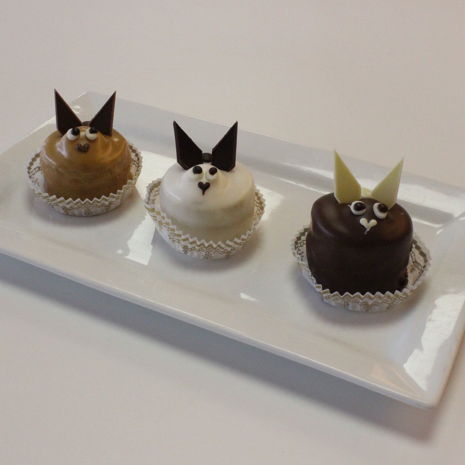 3 bunny pastries and a chick pastry on a white plate.