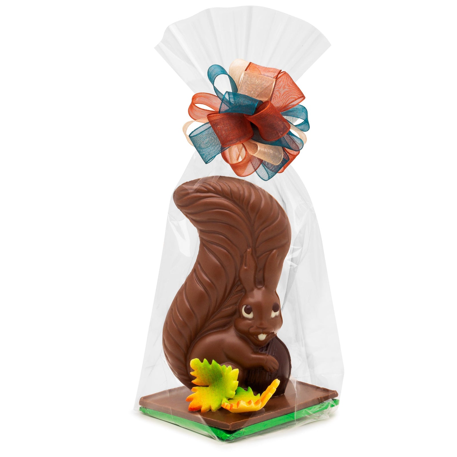 Milk chocolate squirrel holding a dark chocolate nut with 2 fall colored candy leaves in a clear bag with blue and orange bow.