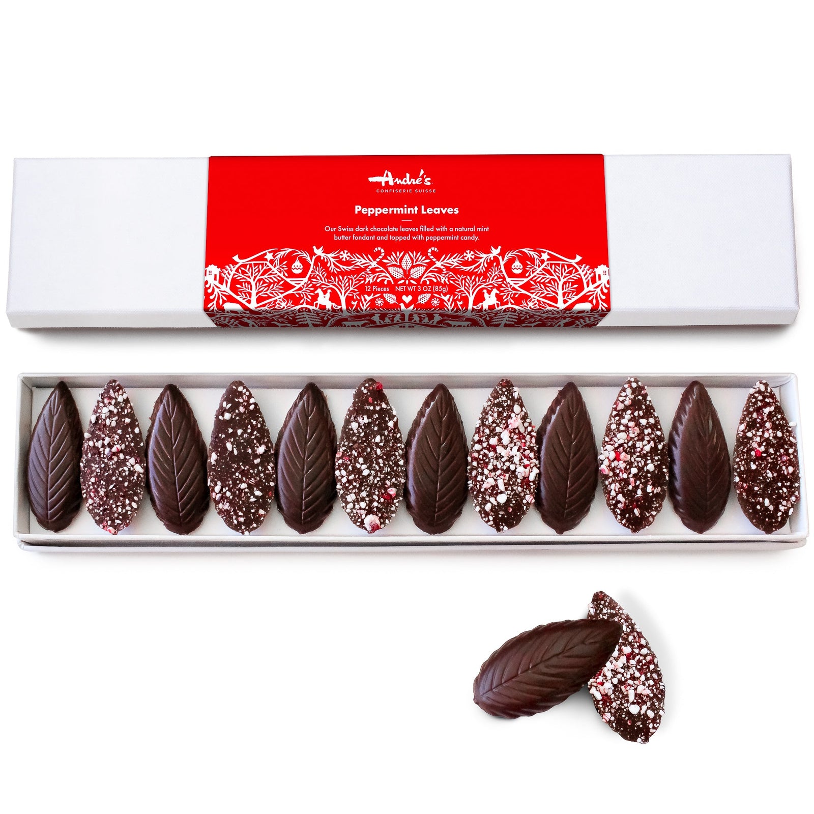 A long white box filled with chocolates that are shaped like mint leaves - every other one upside down to reveal crushed bits of peppermint candy. 