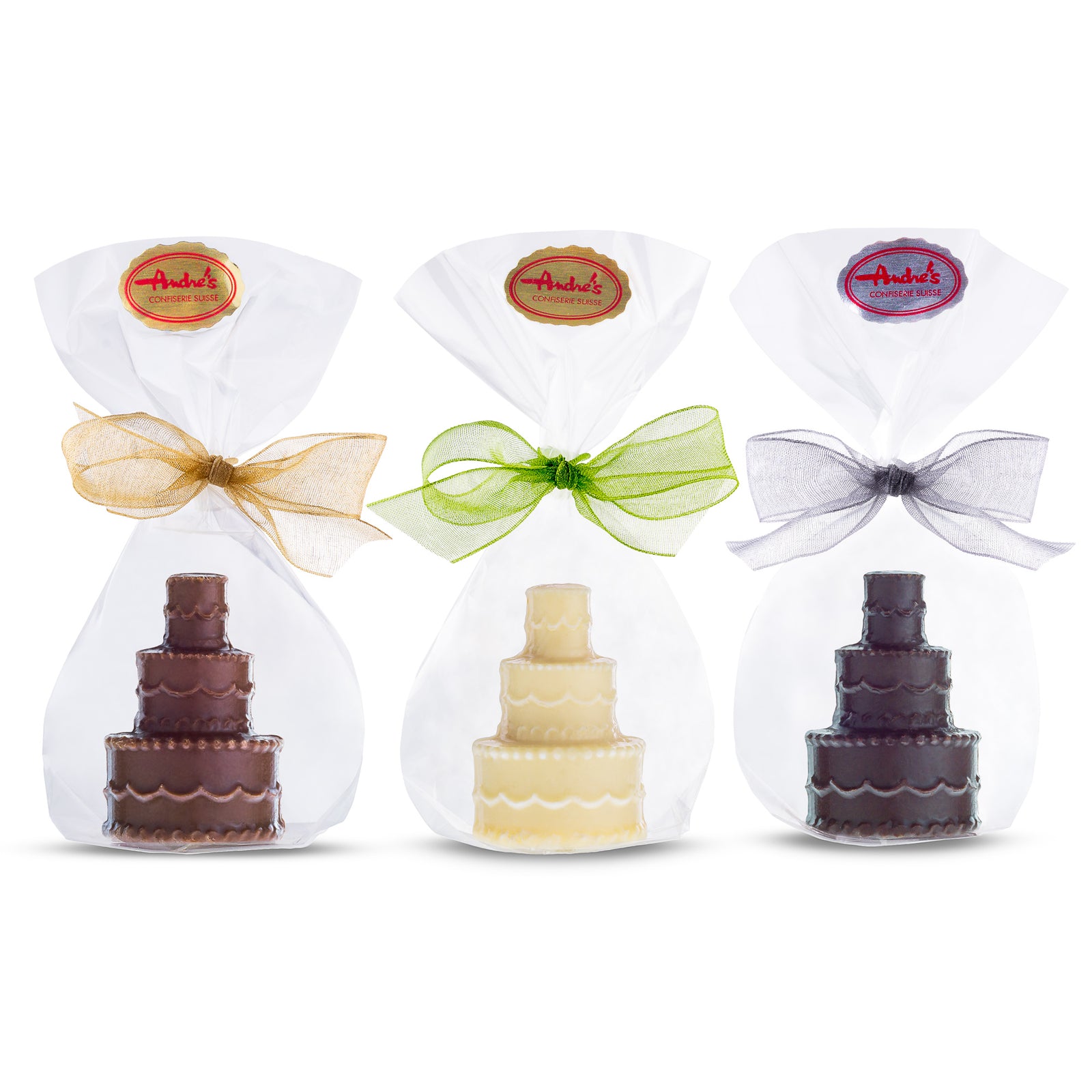 Three miniature chocolate wedding cakes in milk, dark, and white colors, each with a decorative ribbon and a branded label on the top.