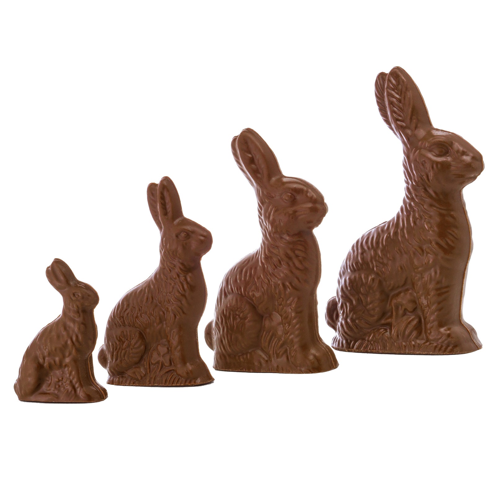 A set of four chocolate bunnies in various sizes, made from milk chocolate and displayed against a white background.