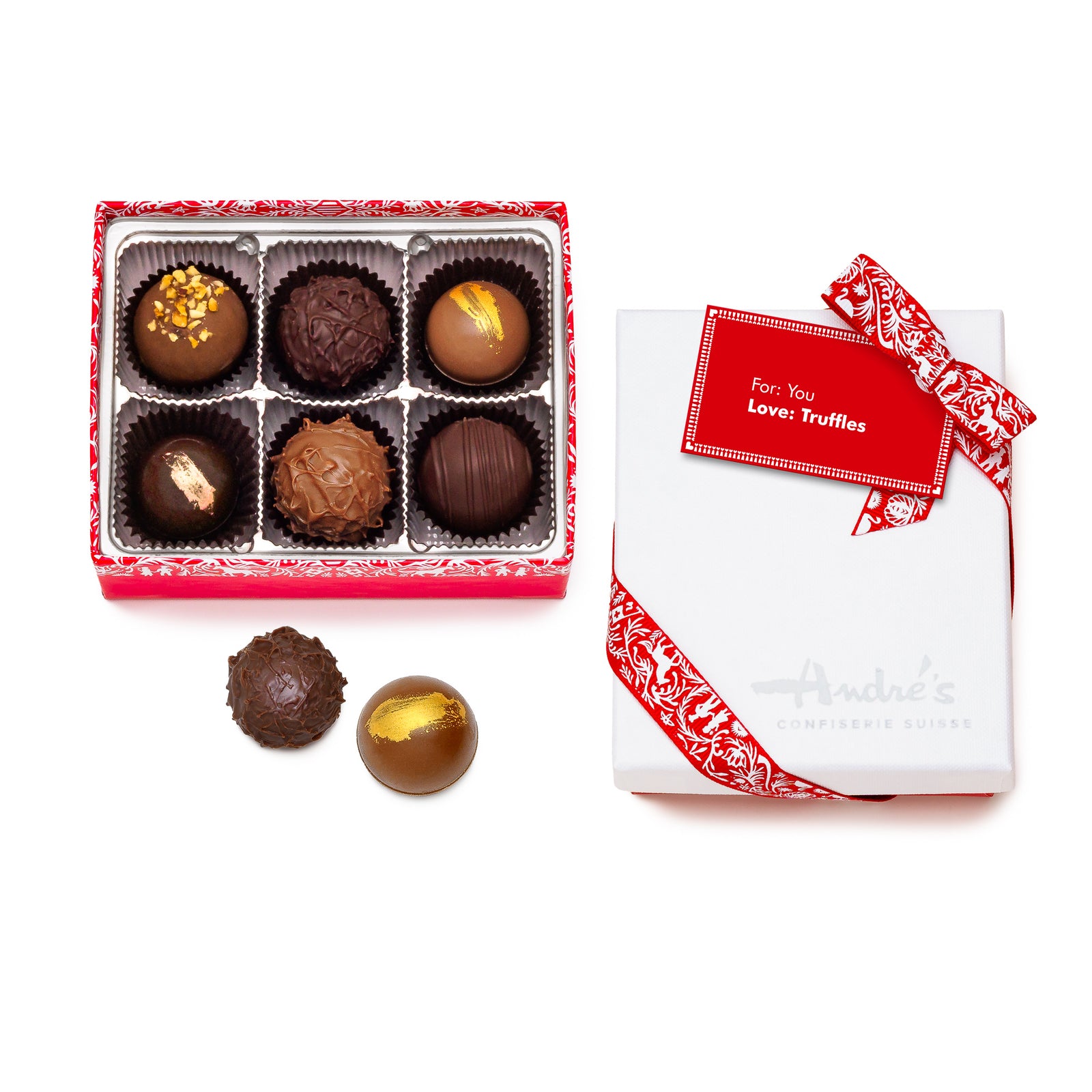 A box of assorted chocolate truffles with a white box wrapped in red ribbon, the truffles vary in color and are topped with different ingredients.