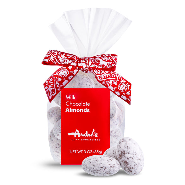Powdered sugar coated milk chocolate almonds in a clear bag with red product label and Swiss print bow.