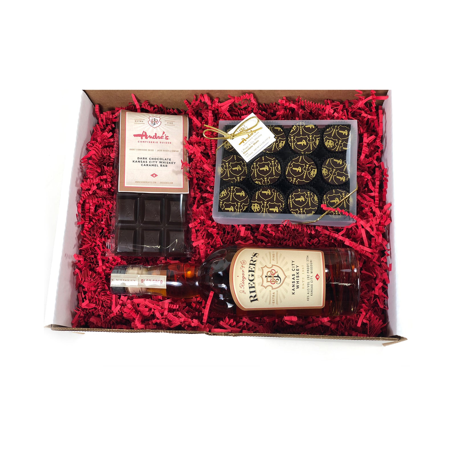 A gift box containing a Kansas City whiskey bottle, a box of chocolate shots, and a bar of whiskey caramel chocolate.