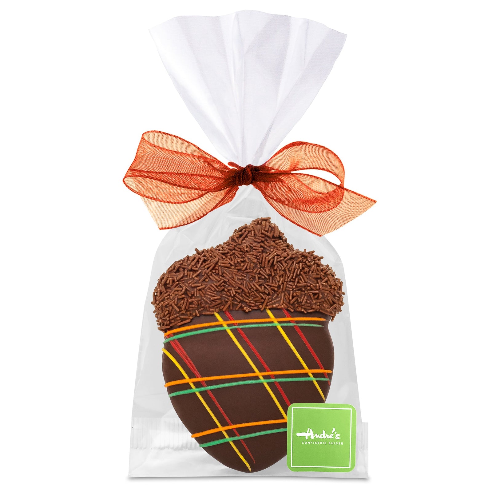 An acorn-shaped cookie, covered in milk chocolate and decorated with fall colored icing and chocolate sprinkles, in a clear bag with a orange bow and green Andre's logo sticker.